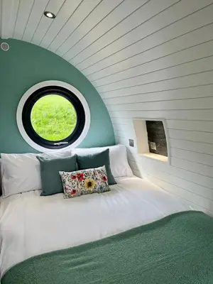 a bedroom with a large bed with a round window at Y Dderwen in Oswestry
