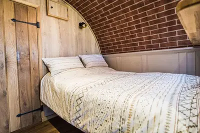 a bed in a room with a brick wall at Mountain View in Llanfair Caereinion