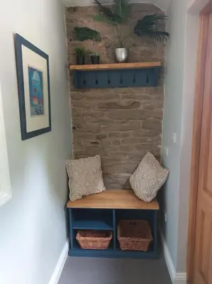 a room with a bench and a brick wall at The Hen Den in Ludlow