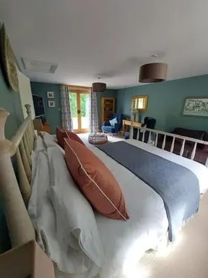 a bedroom with a large bed with pillows on it at The Hen Den in Ludlow
