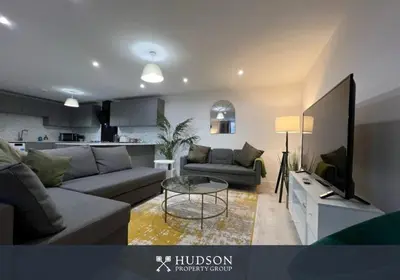 a living room with a couch and a table and a tv at Open Plan Townhouse in Shrewsbury in Shrewsbury