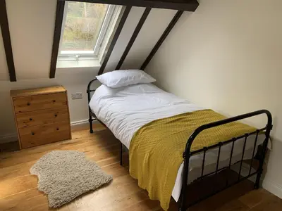 a bedroom with a bed and a window at St Milburga Chapel in Stoke Saint Milborough
