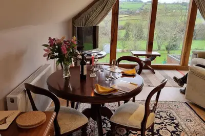a dining room with a table and chairs and a window at Delightful Country Cottage in a lovely rural area in Ludlow