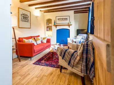 a living room with a red couch and chairs at Cosy 2 bedroom Victorian Cottage - Pass the Keys in Ludlow