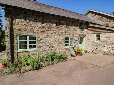 an old stone building with a door and windows at Walkmill Barn in Bishops Castle