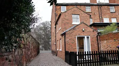 a brick building with a gate and a fence at Abbey Foregate in Shrewsbury