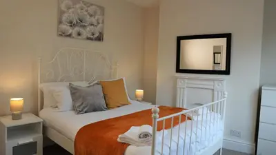 a bedroom with a white bed and a mirror at Abbey Foregate in Shrewsbury