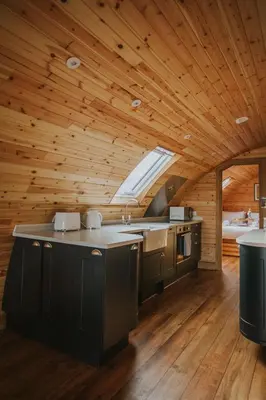a kitchen in a log cabin with a large window at Buttercup in Rhayader
