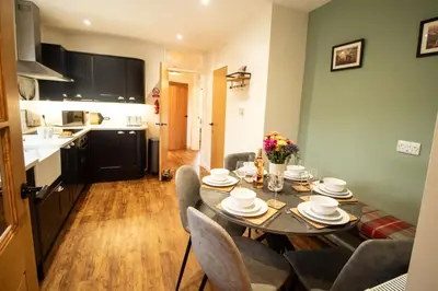 a kitchen and dining room with a table and chairs at Ger Yr Afon in Saint Harmon