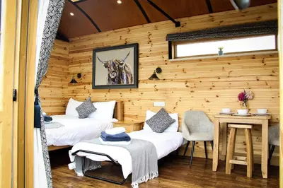a room with two beds and a table in it at Lily in Rhayader