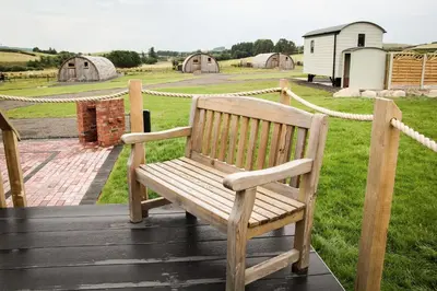 a wooden bench sitting on top of a wooden deck at Lily in Rhayader