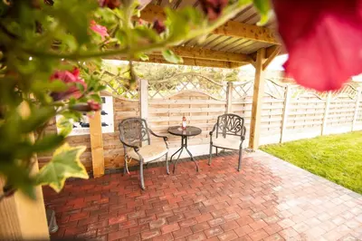 two chairs and a table on a brick patio at Poppy in Rhayader