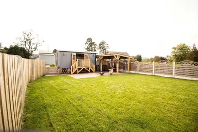 a yard with a fence and a house at Poppy in Rhayader
