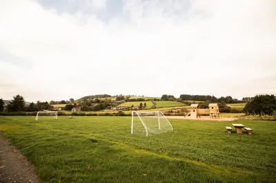 a field with two soccer goals in the grass at Poppy in Rhayader