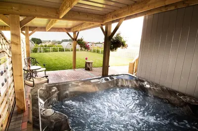 a hot tub on a screened in porch at Poppy in Rhayader