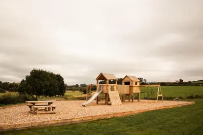 a playground with a slide and a bench at Poppy in Rhayader