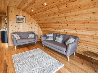 a living room with two couches and a rug at Primrose in Rhayader