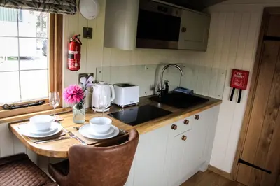 a kitchen with a table with two chairs and a sink at Rose in Rhayader