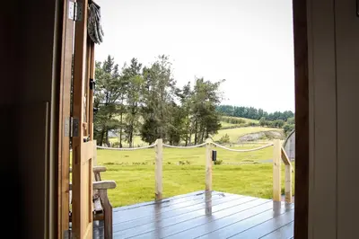 an open door to a porch with a view of a field at Rose in Rhayader