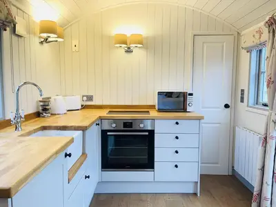 a kitchen with white cabinets and a counter top at Sunflower in Saint Harmon