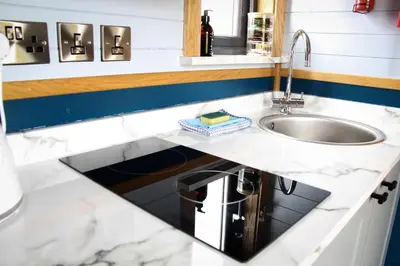 a kitchen counter with a sink and a mirror at Tulip in Rhayader