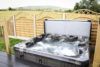 a hot tub on a table with a fence at Tulip in Rhayader