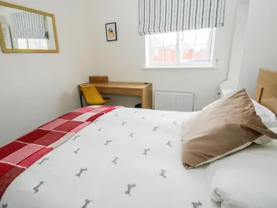 a bedroom with a bed with a pillow and a desk at 30 Poplar Close in Shrewsbury