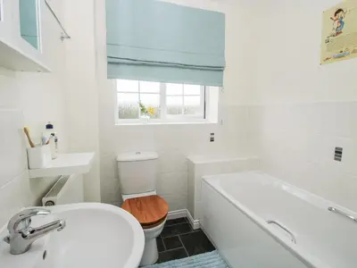 a bathroom with a toilet and a tub and a sink at 30 Poplar Close in Shrewsbury