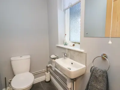 a white bathroom with a toilet and a sink at Pen Y Banc in Builth Wells