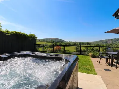 a hot tub in a backyard with a table and chairs at Pen Y Banc in Builth Wells