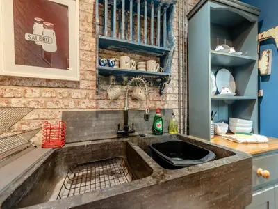 a kitchen with a sink and a brick wall at Tegfan in Henfynyw Upper