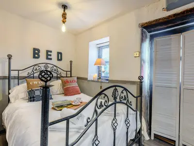 a bedroom with a bed with a black iron bed frame at Tegfan in Henfynyw Upper