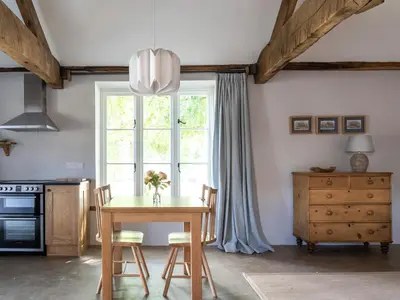 a kitchen with a table with chairs and a window at Blackrock Barn in Clifford