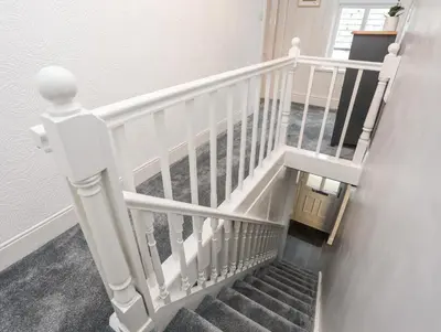 a staircase with white railings in a house at Llys Mair in Bala