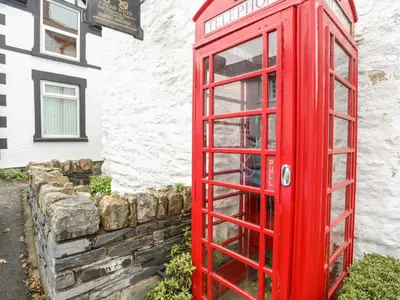 a red phone booth in front of a building at Llys Mair in Bala