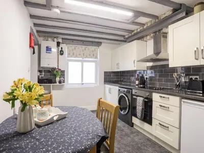 a kitchen with a table with a vase of flowers at Llys Mair in Bala