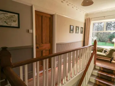 a staircase in a house with a wooden door at Tirallen in Llanwrda