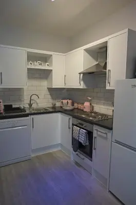 a kitchen with white cabinets and white appliances at Ground floor well appointed cosy flat in Ludlow in Ludlow