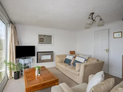 a living room with a couch and a tv at Bramble Bank in Harlech