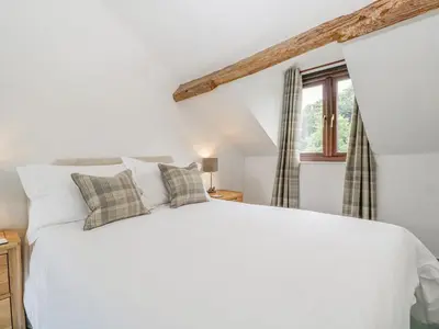 a bedroom with a white bed and a window at Fieldfare in Leominster