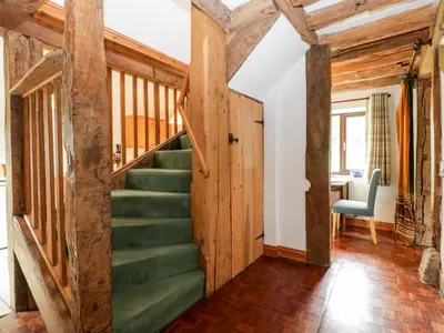 a staircase in a house with wooden walls at Redstart Cottage in Leominster