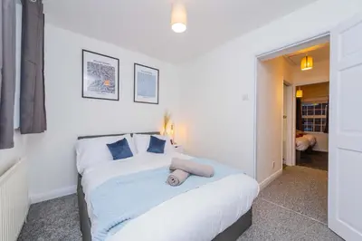 a bedroom with a large white bed with blue pillows at Hereford Road Shrewsbury Cottage in Shrewsbury