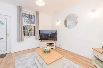 a living room with a television and a table at Hereford Road Shrewsbury Cottage in Shrewsbury