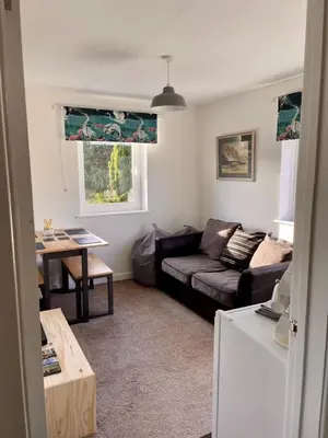 a living room with a couch and a table at Taylor Way - Superb Apartment with Living Room and Private Gated Parking in Aberystwyth