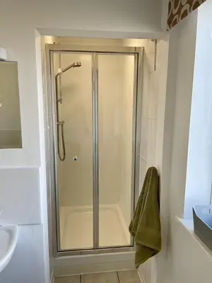 a shower stall in a bathroom with a sink at Taylor Way - Superb Apartment with Living Room and Private Gated Parking in Aberystwyth