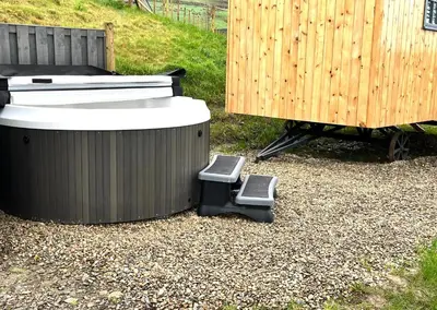 two trash cans sitting on the ground next to a fence at Oakies Farm Stays in Llandovery