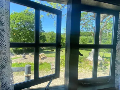 a window looking out at a field outside at Oakies Farm Stays in Llandovery
