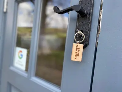 a lock on a door with a tag on it at Oakies Farm Stays in Llandovery