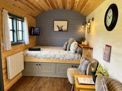 a bedroom with a bed in the corner of a room at Oakies Farm Stays in Llandovery