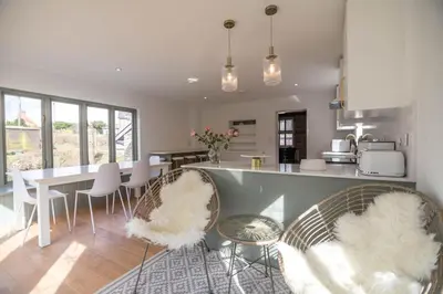 a kitchen with chairs and a table in a kitchen at Luxury Cottage near Hay-on-Wye in Llanigon